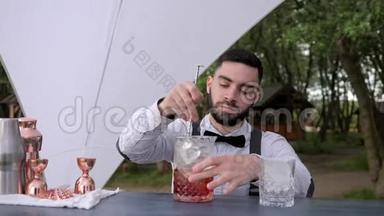 酒吧柜台的酒吧服务员用冰块搅拌酒精，酒吧服务员在户外饮用酒精饮料